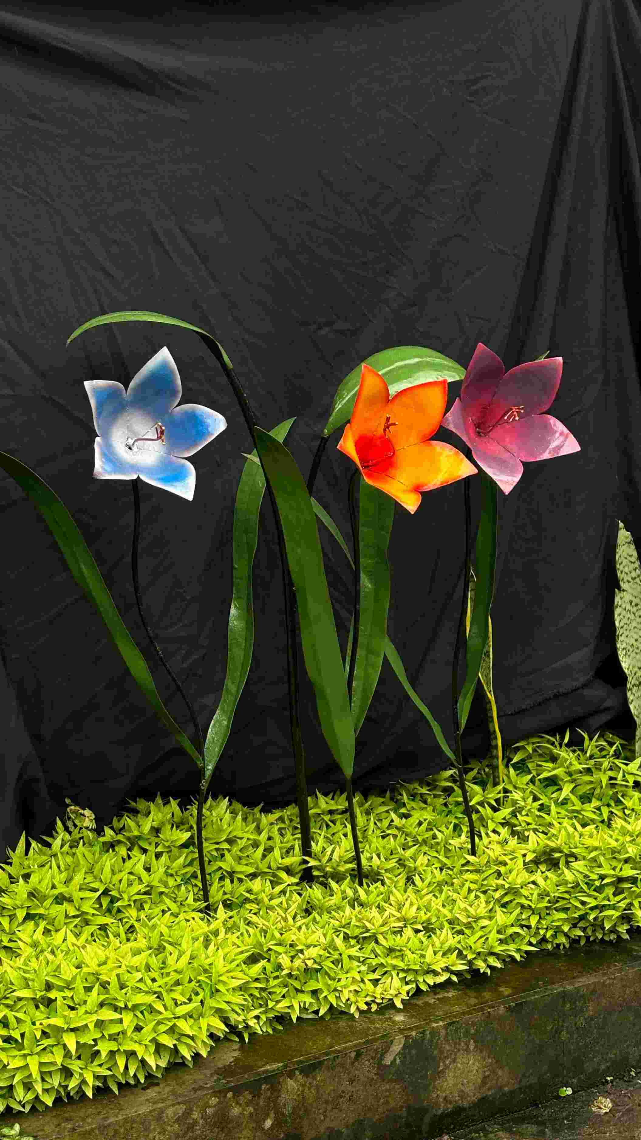 Colorful flower decorations crafted from recycled oil drums, showcasing Henart.design's creativity and sustainability